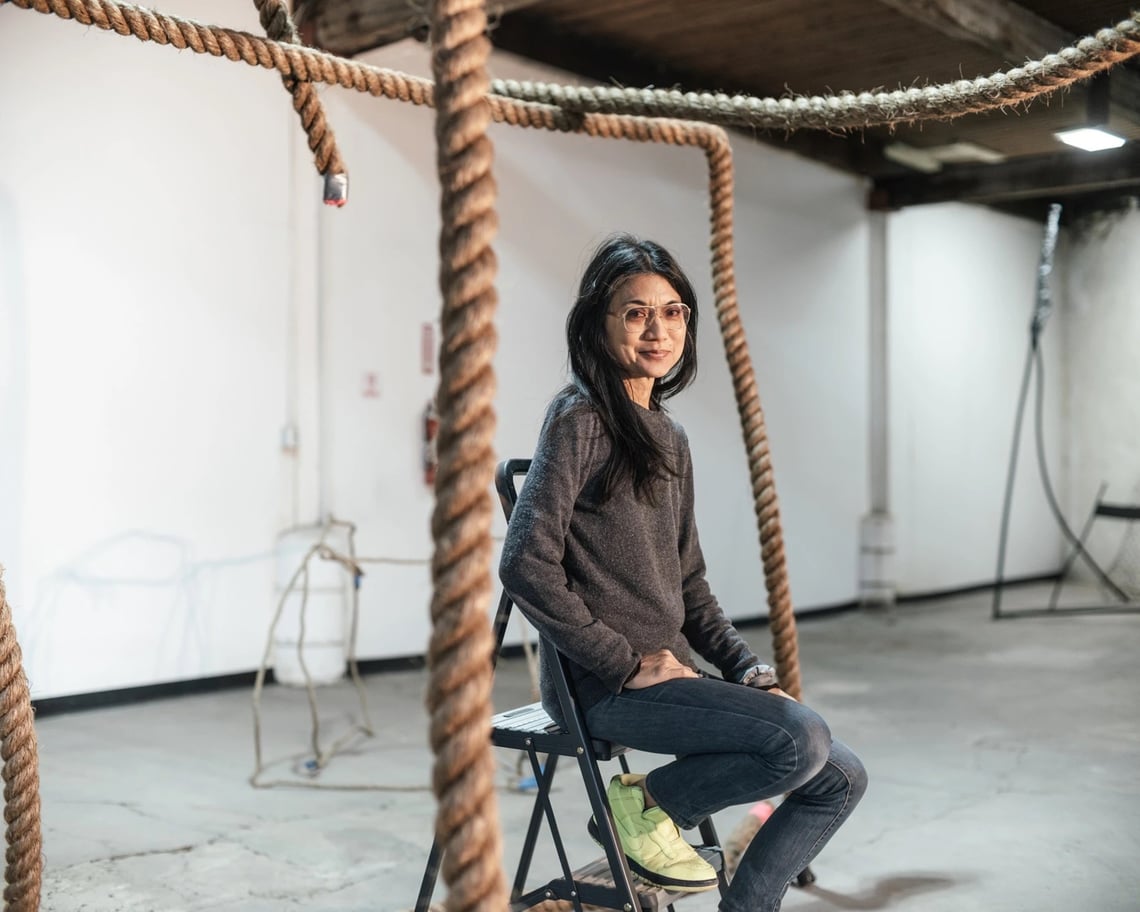 Image of Michelle Lopez surrounded by cascading angular rope sculpture